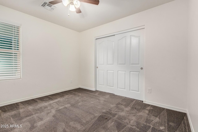 unfurnished bedroom featuring carpet, a closet, visible vents, and baseboards