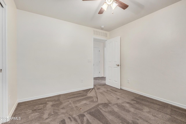 empty room featuring carpet, visible vents, ceiling fan, and baseboards