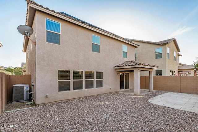 back of house featuring central air condition unit, a fenced backyard, a patio, and stucco siding