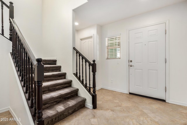 entrance foyer with stairway and baseboards