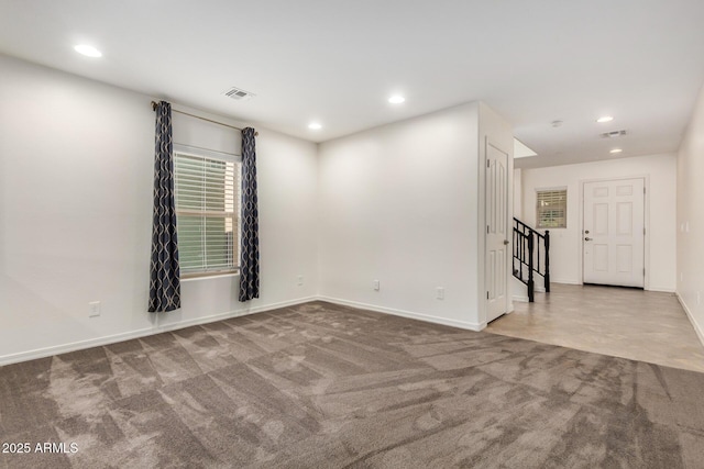 carpeted empty room featuring baseboards, visible vents, and recessed lighting