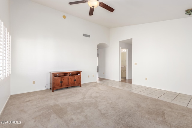 spare room featuring light carpet, ceiling fan, and high vaulted ceiling