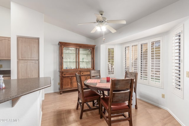 dining room featuring light wood-type flooring, vaulted ceiling, and ceiling fan