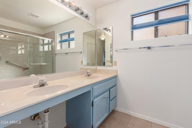 bathroom with tile patterned flooring, a shower with door, and vanity