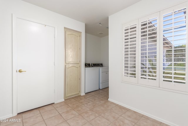 hall featuring light tile patterned floors and washer and dryer