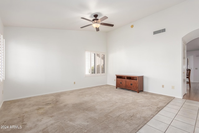 unfurnished room with vaulted ceiling, ceiling fan, and light colored carpet