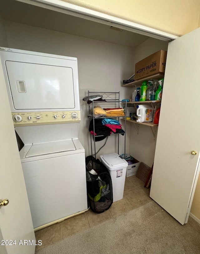 clothes washing area with stacked washer and clothes dryer and light tile patterned floors