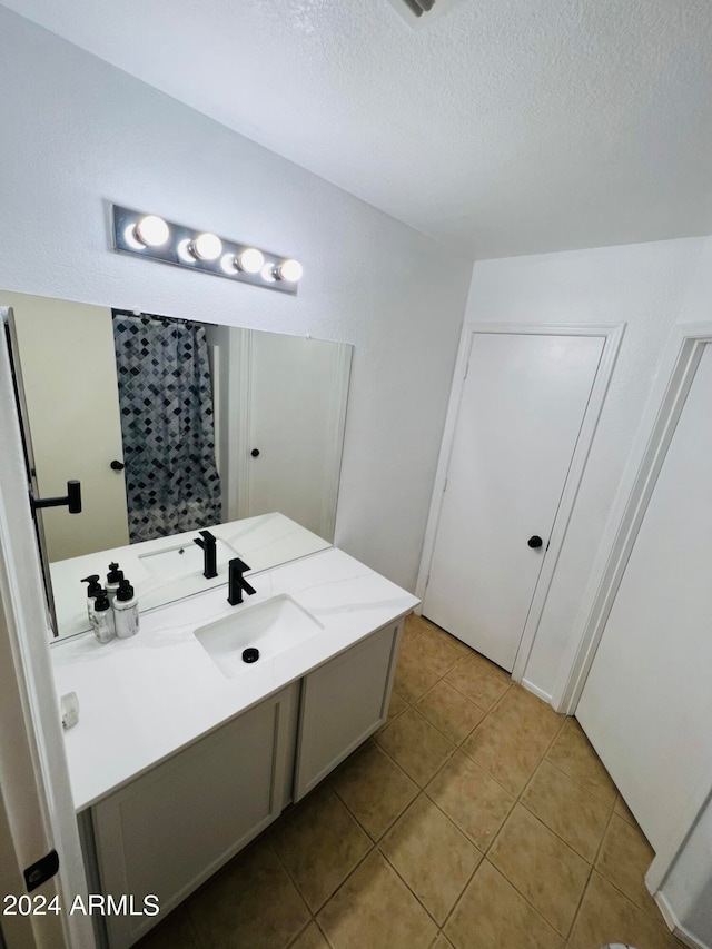 bathroom featuring vanity, tile patterned flooring, and a textured ceiling