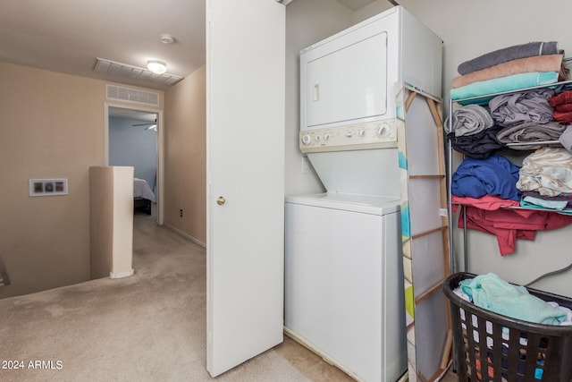 clothes washing area featuring stacked washer and clothes dryer and light colored carpet