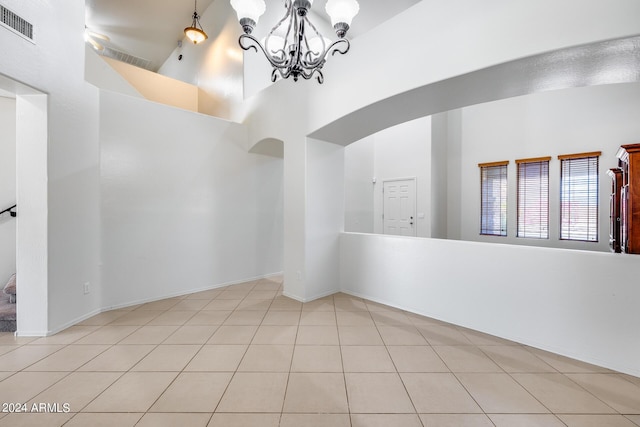 empty room with a chandelier and light tile patterned floors