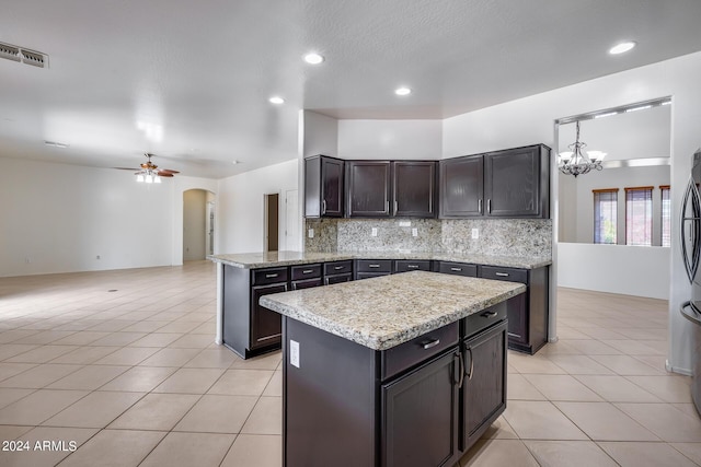 kitchen featuring decorative light fixtures, ceiling fan with notable chandelier, tasteful backsplash, and light tile patterned floors