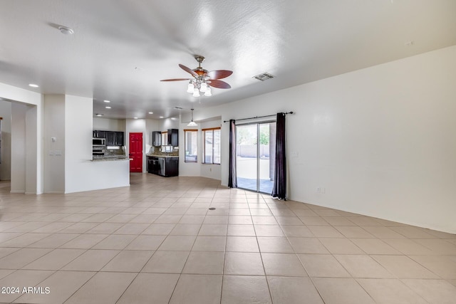 unfurnished living room featuring ceiling fan and light tile patterned flooring