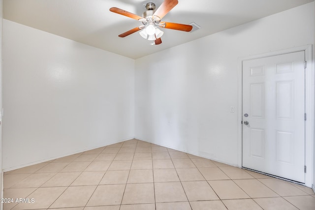 tiled spare room with ceiling fan