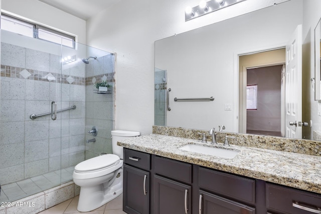 bathroom featuring toilet, tile patterned flooring, a shower with shower door, and vanity