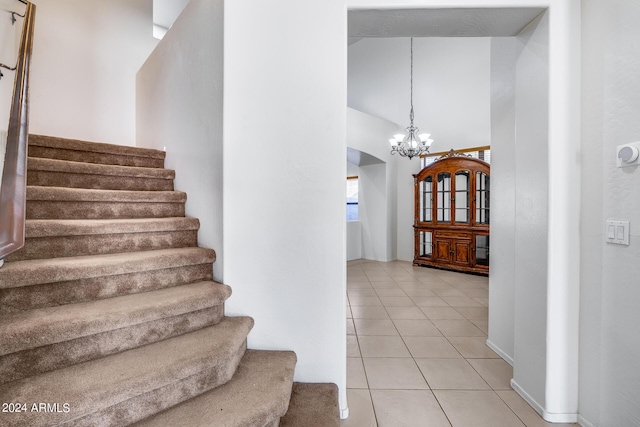 stairway featuring an inviting chandelier and tile patterned floors