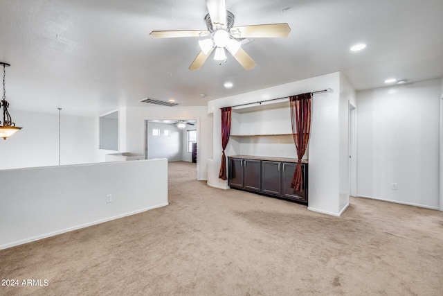 unfurnished living room featuring ceiling fan and light colored carpet