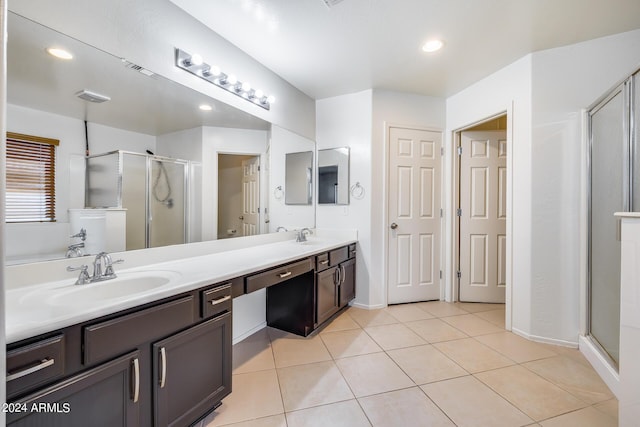 bathroom featuring tile patterned flooring, a shower with door, and vanity