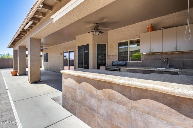 view of patio with ceiling fan and sink