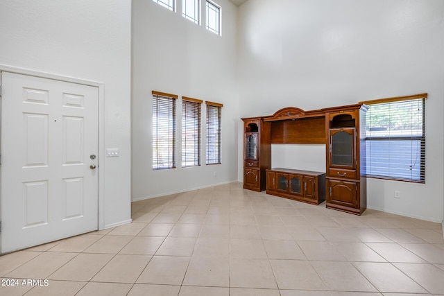 tiled foyer entrance featuring a high ceiling and a healthy amount of sunlight