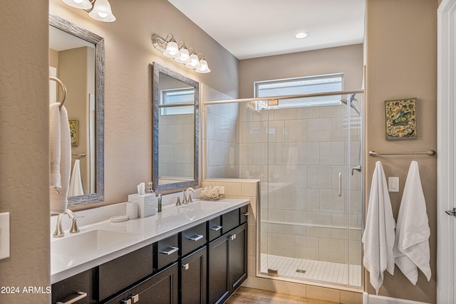 bathroom with a shower with door and vanity