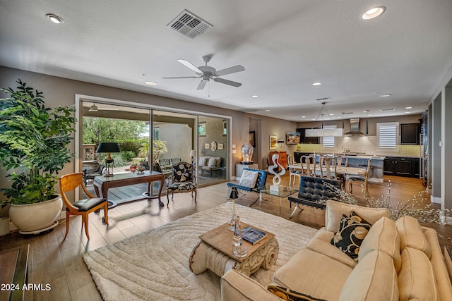 living room featuring light wood-type flooring and ceiling fan