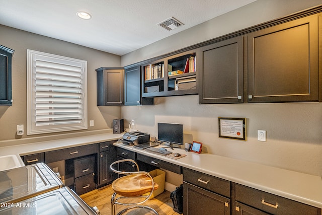 office space featuring built in desk and light hardwood / wood-style flooring