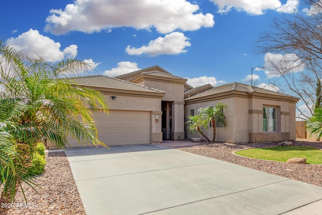 mediterranean / spanish house with a garage, concrete driveway, a tiled roof, and stucco siding