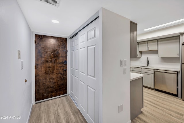 hallway with sink and light hardwood / wood-style floors