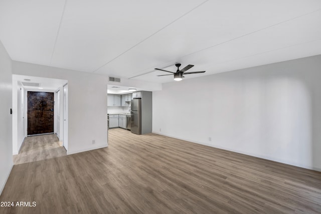 unfurnished living room with light wood-type flooring and ceiling fan