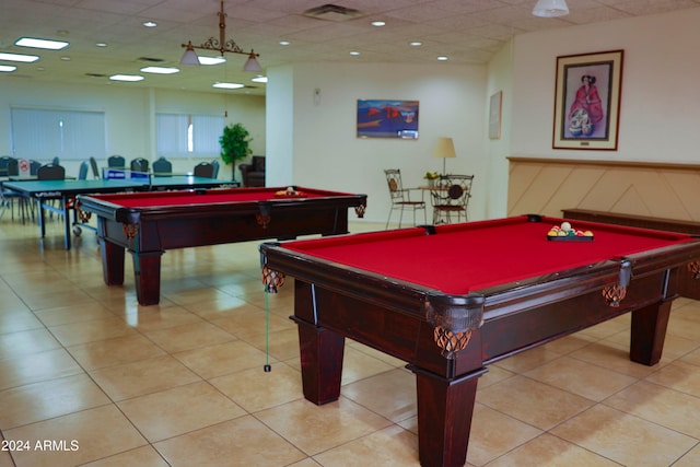 recreation room featuring a paneled ceiling and light tile patterned flooring