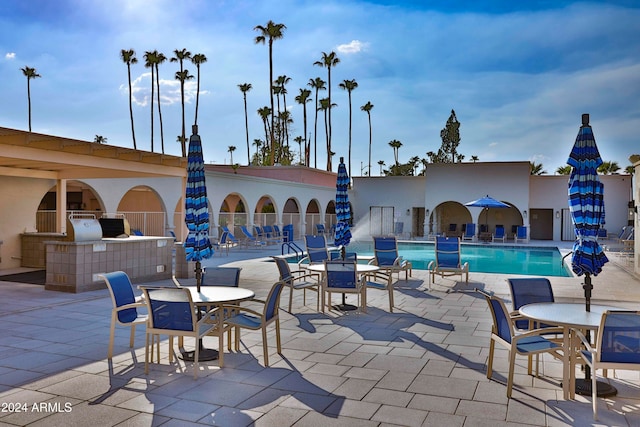 view of patio featuring a community pool and an outdoor kitchen