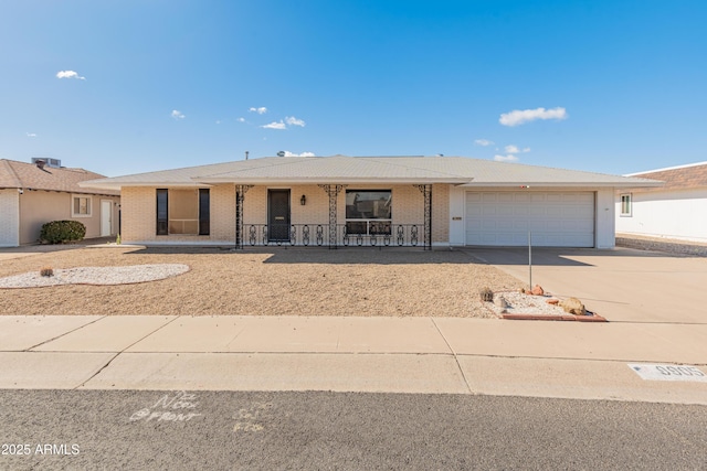 ranch-style house with a garage, concrete driveway, brick siding, and covered porch