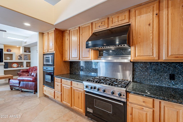 kitchen with under cabinet range hood, stainless steel appliances, open floor plan, dark stone counters, and tasteful backsplash