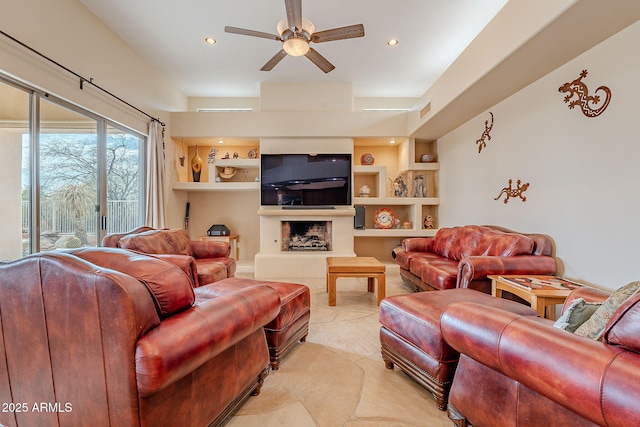 living area with a fireplace with raised hearth, built in shelves, recessed lighting, a ceiling fan, and visible vents