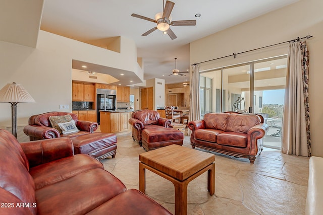 living area with stone finish floor, a ceiling fan, and recessed lighting