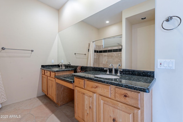 full bathroom featuring double vanity, tile patterned floors, a sink, and tiled shower