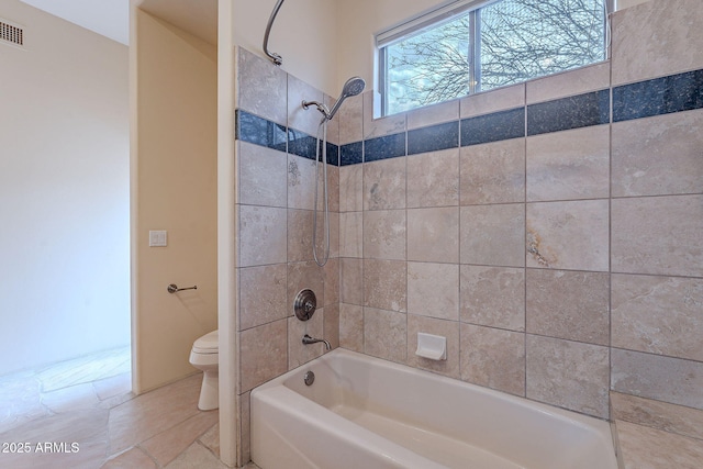 bathroom with visible vents, bathing tub / shower combination, and toilet