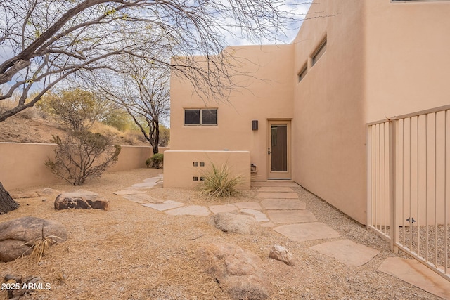 exterior space with fence and stucco siding