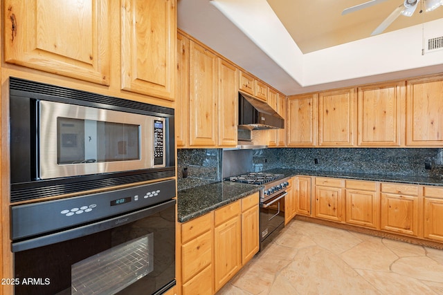 kitchen featuring tasteful backsplash, appliances with stainless steel finishes, light brown cabinets, dark stone counters, and under cabinet range hood