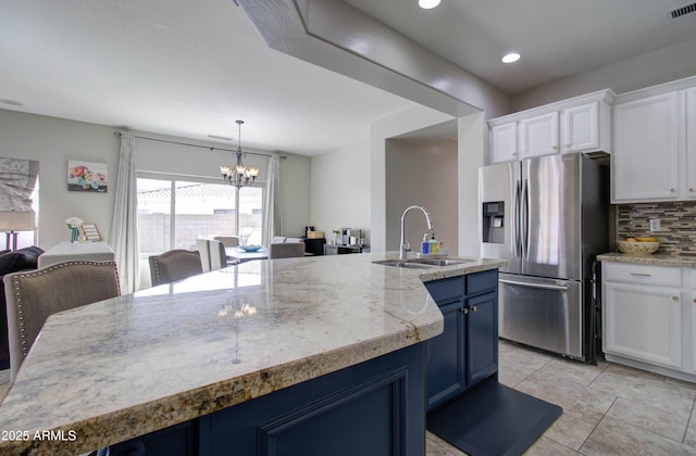 10402 E Javelina Ave, Mesa, AZ 85209 - kitchen with stainless steel fridge, a sink, blue cabinetry, decorative backsplash, and white cabinets