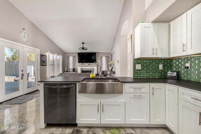 kitchen with dishwasher, dark countertops, open floor plan, a peninsula, and a sink