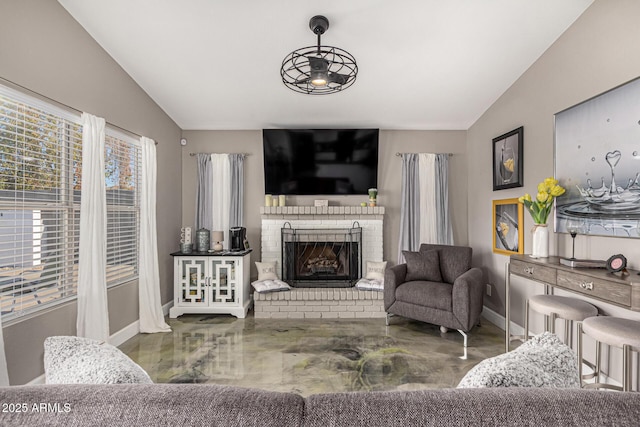 living room featuring vaulted ceiling, a fireplace, and baseboards