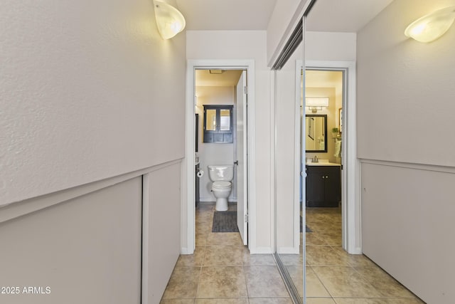 hall with light tile patterned floors and a sink