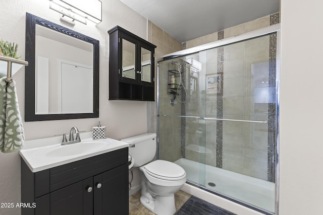 full bathroom featuring toilet, vanity, a stall shower, and tile patterned flooring