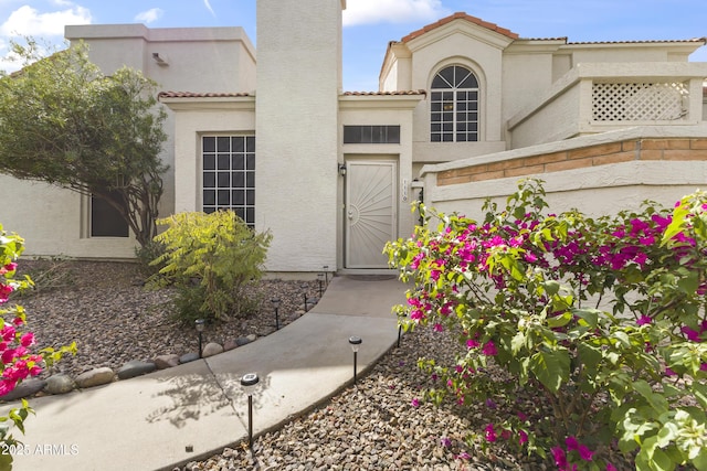 entrance to property featuring stucco siding and a tiled roof