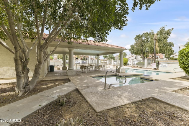 community pool featuring fence, a gazebo, a hot tub, and a patio