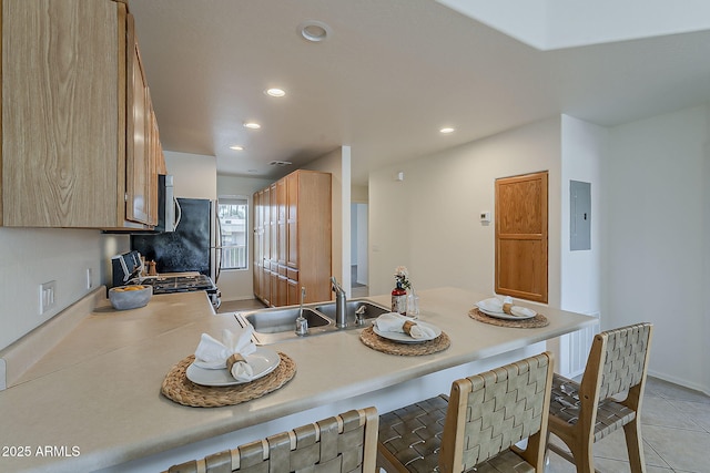 205 N 74th St Unit 261, Mesa, AZ 85207 - kitchen with gas stove, a breakfast bar area, electric panel, light countertops, and recessed lighting