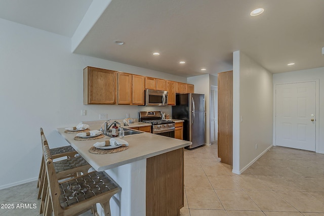 205 N 74th St Unit 261, Mesa, AZ 85207 - kitchen with stainless steel appliances, recessed lighting, light countertops, a breakfast bar, and light tile patterned floors