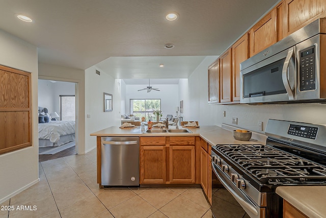 205 N 74th St Unit 261, Mesa, AZ 85207 - kitchen featuring stainless steel appliances, a peninsula, light countertops, light tile patterned floors, and brown cabinets