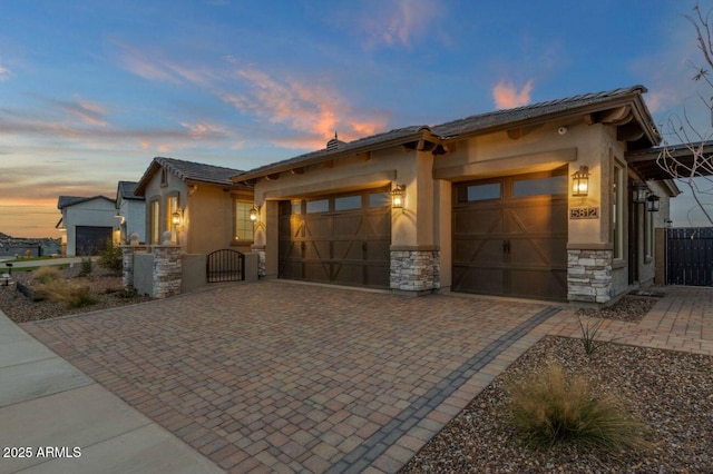 5756 E Star Valley St, Mesa, AZ 85215 - view of front facade featuring decorative driveway, a garage, stucco siding, and stone siding
